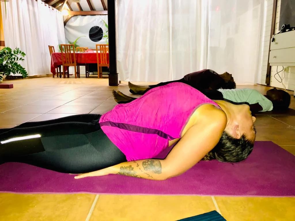 Fin d'un cours de yoga dans le carbet de Happy Qi Institut, pratiquantes allongées en relaxation