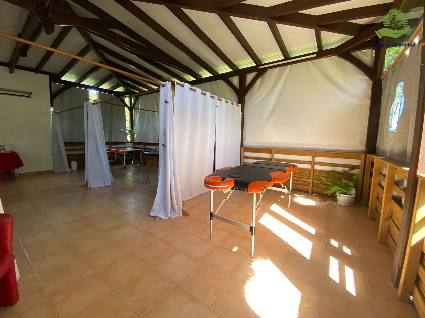 Espace de soins avec rideaux et table de massage