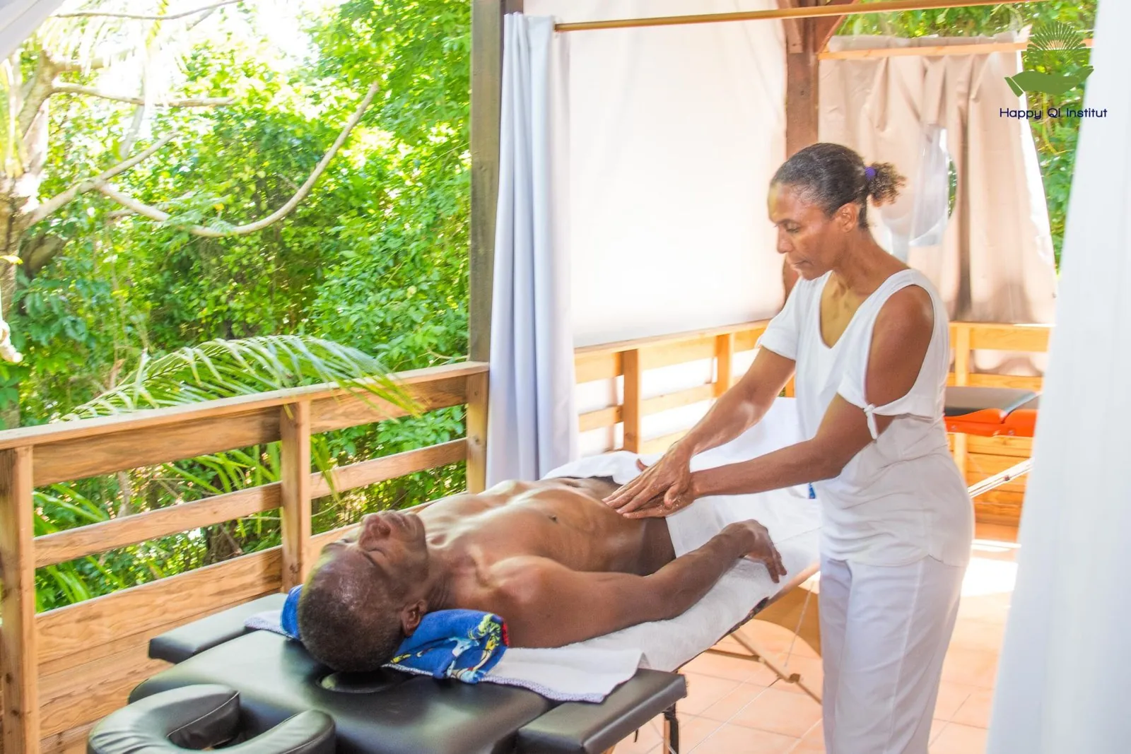 Praticienne de Happy Qi Institut réalisant un soin Tui Na en extérieur, dans le carbet de l'institut à Ducos, Martinique